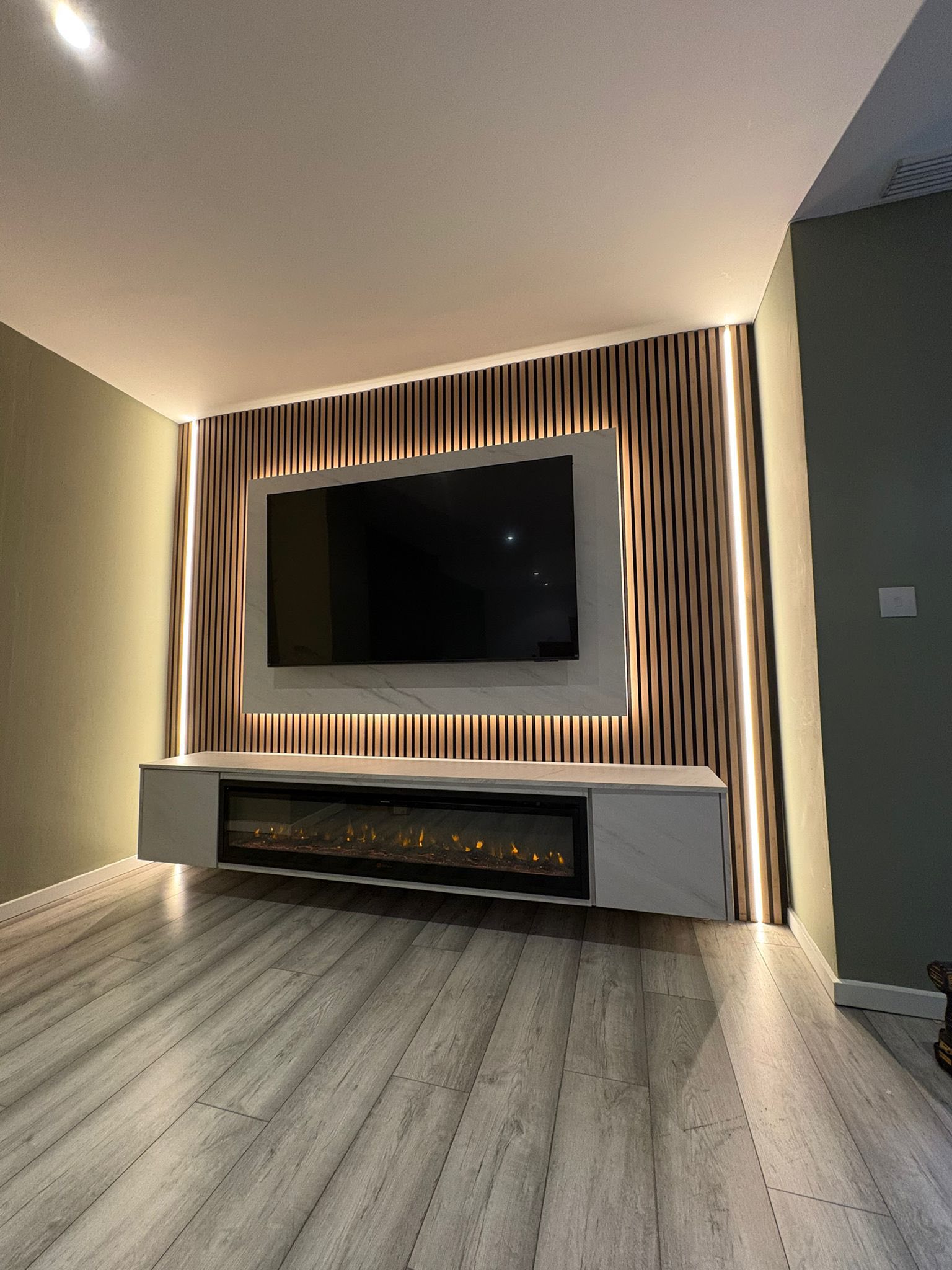 Finished media wall with slat panels and electric fire